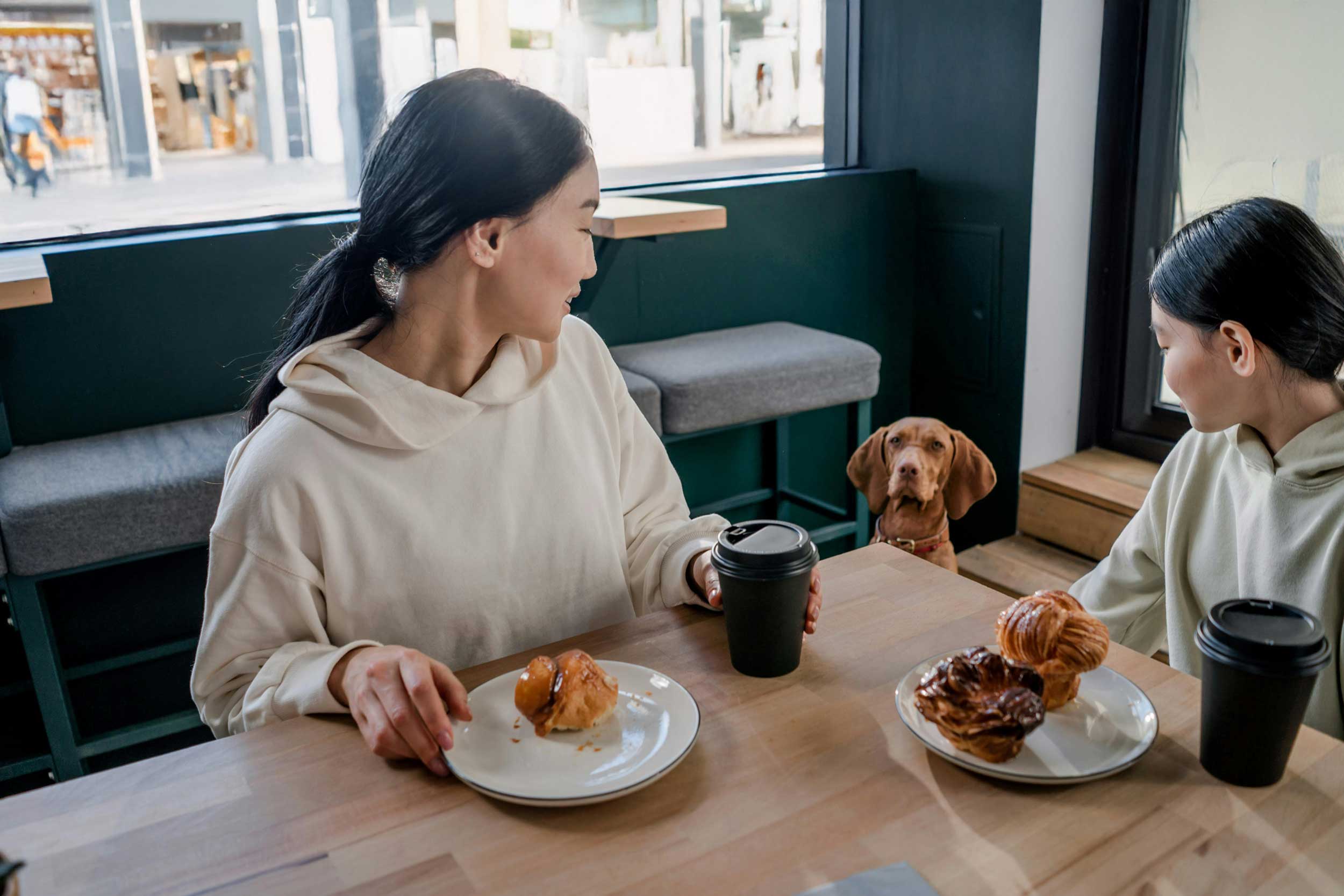 Mother and daughter at coffee shop looking at dog